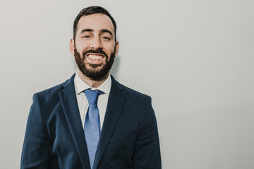 Young businessman, dressed in suit and tie placed on a neutral background. Different facial gestures, expressing emotions. Lifestyle.
