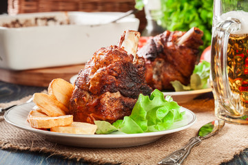 Roasted turkey knuckle with fried potato slices