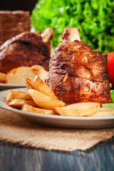 Roasted turkey knuckle with fried potato slices