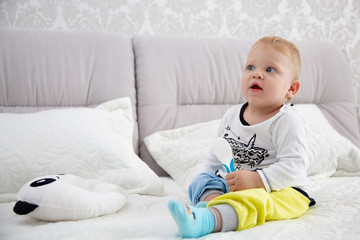 Playful little boy wearing blue pyjamas in bed