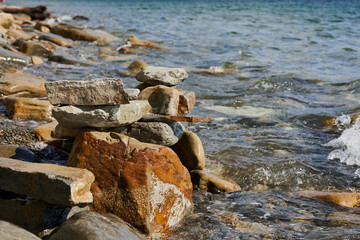 Several randomly stacked stones against the background of sea water.. Black Sea, Supseh, Anapa, Krasnodar region, Russia.