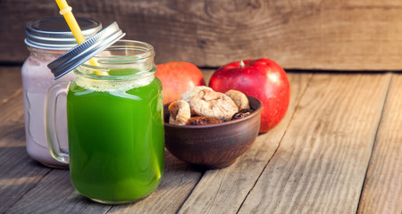 Smoothie in glass jar on rustik wood. Green healthy beverage and fresh fruit
