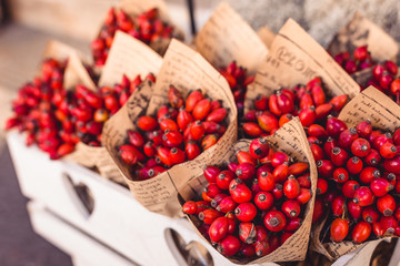 Cornelian cherries as bouquet in the paper with words, in the white, wooden box, autumn decoration