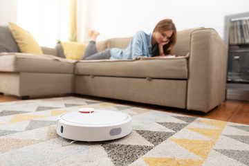 Robotic vacuum cleaner cleaning the room - obrazy, fototapety, plakaty
