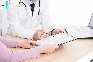 Doctor and patient are discussing something, just hands at the table, medical insurance.