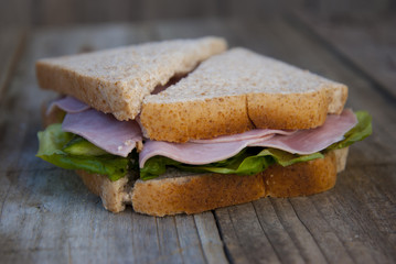 Club Sandwich with Ham and Vegetables. Rustic wooden background.