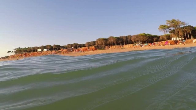 Shooting from sea, sunset and waves cover camera. Portugal Algarve.
