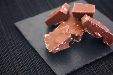 Broken pieces of milk chocolate with nuts