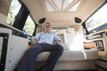 Relaxed businessman in moving car.  