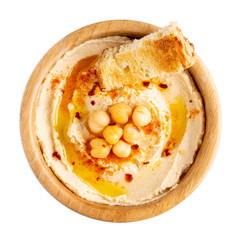 Classic chickpea hummus with olive oil and paprika served with bread in wooden bowl isolated on white