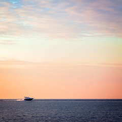 Naklejka na ściany i meble Boat on the lake swims into the sunset