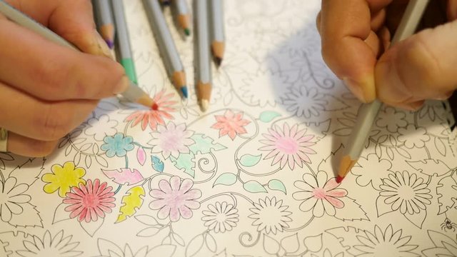 Couple drawing a pencil at home an Adult coloring book