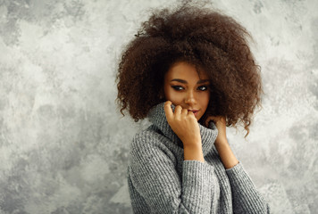 Portrait of young black woman with an afro hair wear high-neck wool and cashmere sweater
