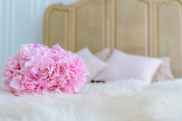 A pink flower bouquet is placed on the bed.