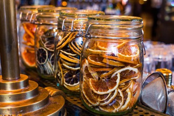 Sliced dry orange in the glass jar as ingredient for drinks and autumn, winter decoration