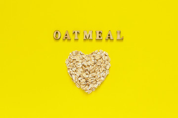 Text Oatmeal and oat flakes in the shape heart on yellow background.