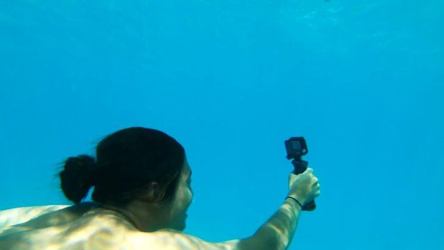 Man dives in coral reef with camera, POV