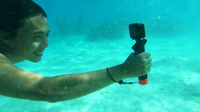 Man swims underwater with camera, POV