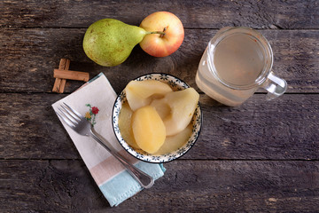 Bowl with cooked apples and pears and jug of syrup 