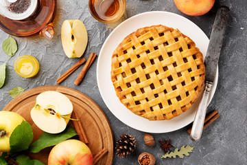 Popular American apple pie piece and cup of tea on gray table background. top view.