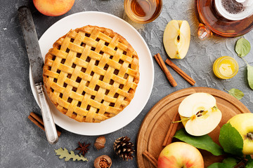 Popular American apple pie piece and cup of tea on gray table background. top view.