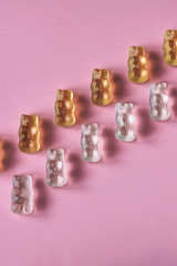 White and yellow jelly bears on pink background 