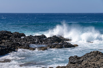 Atlantic ocean waves crashing over volcanic lava rocks on La Palma Island, Canary Islands, Spain