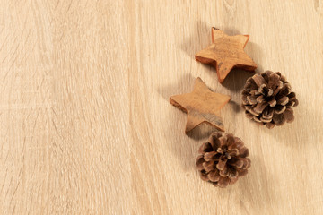 Wooden christmas stars and pine cones as christmas decoration on wooden background