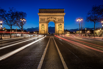 Fototapeta na wymiar Arc de triomphe de nuit vu depuis les Champs-Elysées avec des filés de lumière de voitures