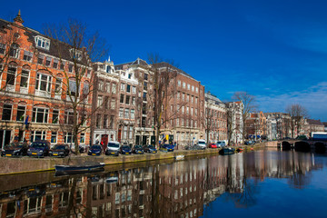 Fototapeta na wymiar Canals, boats and beautiful architecture at the Old Central district in Amsterdam