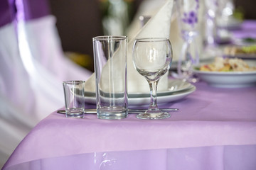 Beautiful table setting with crockery and flowers for a party, wedding reception or other festive event. Glassware and cutlery for catered event dinner