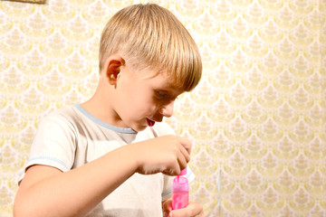 The boy blows soap bubbles, close-up.