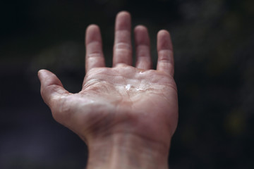 Raindrops on the palm. Hand in open window