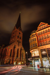 City view of Hamburg downtown at night. View of St. Petri church and traditional red brick buildings. Long exposure. Car light trails. Hamburg, Germany