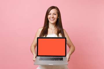 Naklejka premium Portrait of joyful bride woman in wedding dress hold laptop pc computer with blank black empty screen isolated on pastel pink background. Wedding to do list. Organization of celebration. Copy space.