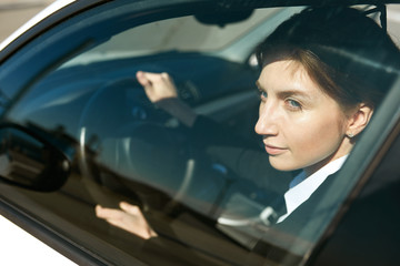 Mid-age business woman working while being in the car