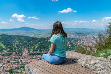 Naklejka na ściany i meble Girl admiring the overview of Brasov city from Tampa mountain in Brasov, Romania