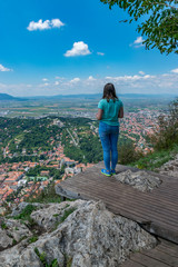 Fototapeta premium Girl admiring the overview of Brasov city from Tampa mountain in Brasov, Romania