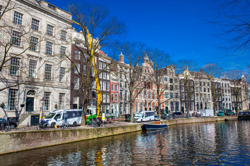 Fototapeta premium Canals, boats and beautiful architecture at the Old Central district in Amsterdam