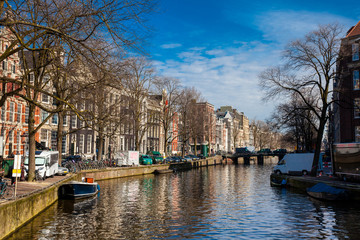 Fototapeta na wymiar Canals, boats and beautiful architecture at the Old Central district in Amsterdam
