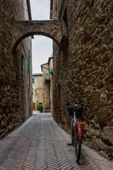 Red old bicycle in a little alley of a medieval village