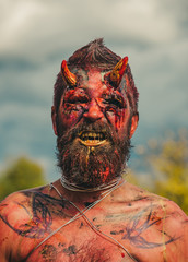 Halloween satan with red blood and wounds on face skin