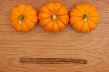 Pumpkin Spice background with a pumpkins and cinnamon sticks on wood