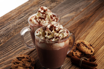 Hot chocolate cocoa with whipped cream on table.