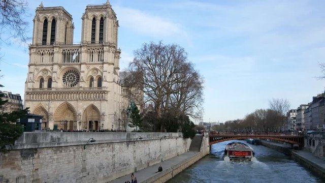 Cathedral Notre Dame (outside) and a boat on the Seine River on a beautiful spring day. (Paris, France)