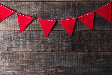 Fototapeta premium Red triangle flags hanging over wooden background