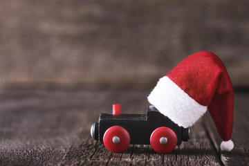 Old toy of train with Santa Claus helper hat on it