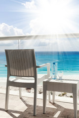 Balcony with plastic bottle of water on  table overlooking an ocean