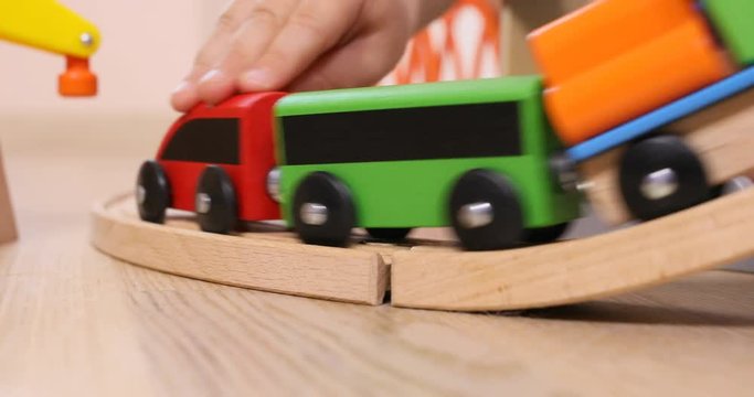 Three years old child boy play with wooden train, build toy railroad at home. Toddler boy play with cars. Educational toys for preschool and kindergarten child, indoor playground, lifestyle concept