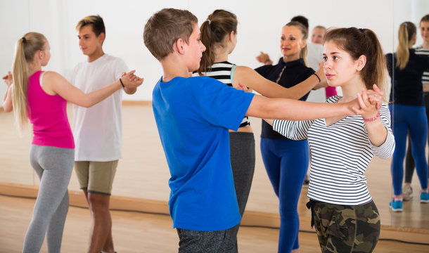 Group of concentrated teen dancing tango in dance studio